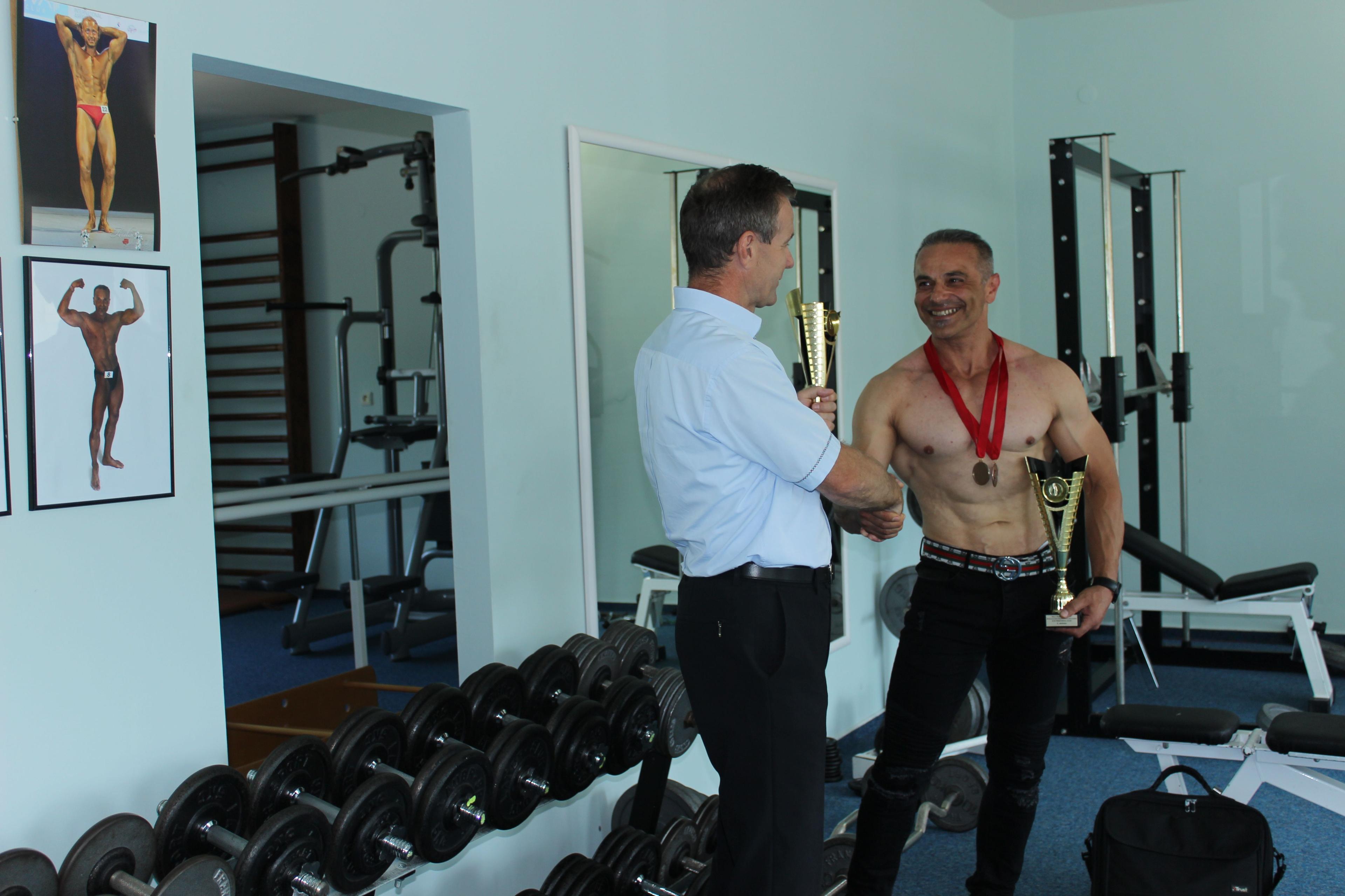 dvaja muži si podávajú ruky vo fitness centre